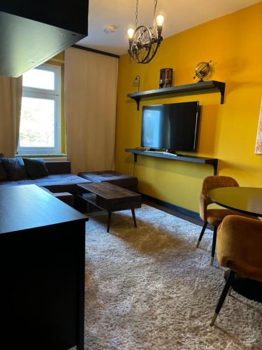 a living room with a couch and a tv at FewoCompany in Leipzig