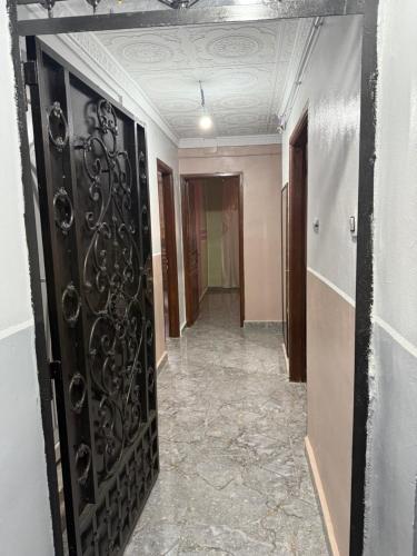 a hallway with a black door in a room at Villa SAAD in Khenchela