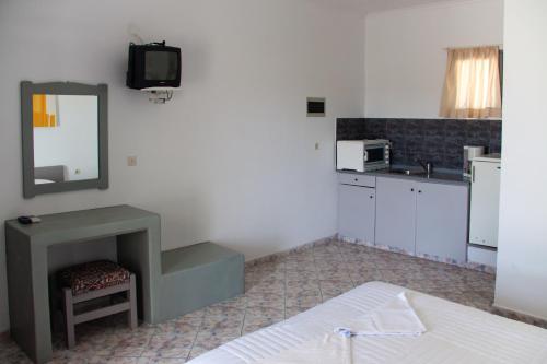 a room with a bed and a sink and a mirror at Parasporos Village in Adamas