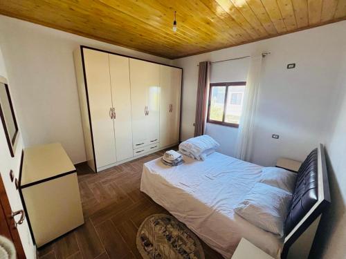 a bedroom with a bed and a wooden ceiling at Bert-House close to the sea in Lezhë