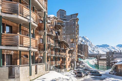 un bâtiment dans la neige avec des voitures garées devant dans l'établissement Résidence Les Alpages - maeva Home - Appartement 2 pièces 4 personnes - Sélection MAE-0171, à Avoriaz