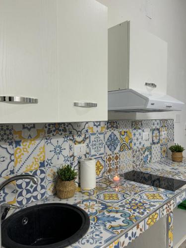 a kitchen with a sink and a counter with tiles at Le Stanze del Mare - B&B in Messina