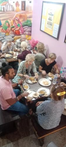 a group of people sitting around a table eating food at Azure Family Paying Guest House in Varanasi