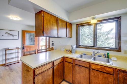 une cuisine avec des armoires en bois, un évier et une fenêtre dans l'établissement Corvallis Coyote Creek House with Mountain Views!, à Corvallis