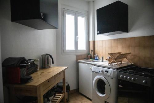 a kitchen with a washing machine and a window at Paris Flea Market Comfy Flat in Saint-Ouen