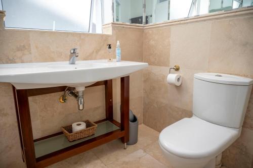 a bathroom with a white sink and a toilet at WATERFRONT - 26 Spinniker in Knysna