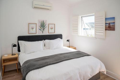 a bedroom with a large white bed and a window at WATERFRONT - 26 Spinniker in Knysna