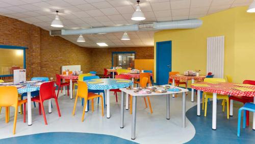 a dining room with tables and colorful chairs at Privately Owned 2-bedroom Caravan at Camber Sands, 1 sofa bed, Private Parking, NO SMOKING NO PETS in Camber