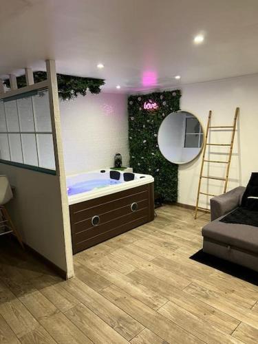 La salle de bains est pourvue d'une baignoire avec une échelle et un miroir. dans l'établissement AppartSpa, à Tremblay-en-France