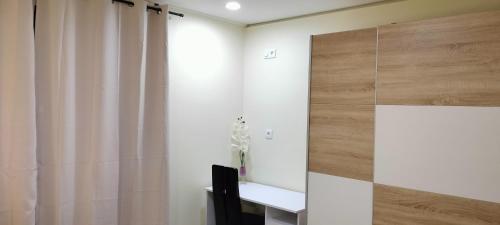 ein weißer Raum mit einem Schreibtisch und einem Vorhang in der Unterkunft Beautiful View 3 Arco da Calheta - Ilha da Madeira in Arco da Calheta