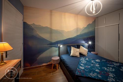 - une chambre avec une fresque murale représentant les montagnes dans l'établissement L'écrin de l'Astoria, à Tresserves
