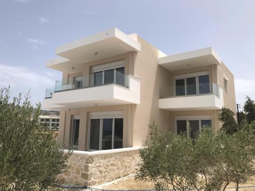a large white house with trees in front of it at Tamaris Suites in Karpathos Town