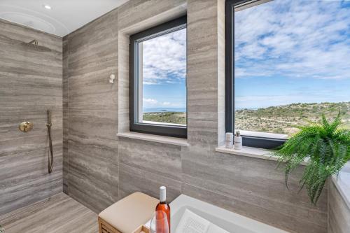 bagno con vasca, finestra e lavandino di NEW Luxury, seaview Villa Grandeca a Rogoznica (Rogosnizza)