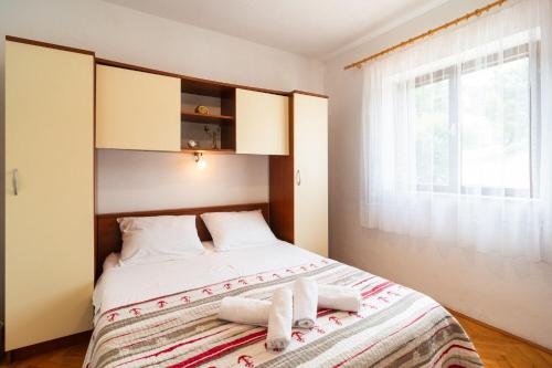 una camera da letto con un letto con asciugamani sopra di Apartment Ivope a Splitska