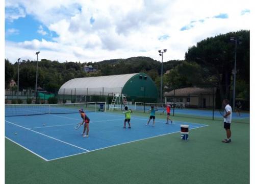 a group of people playing tennis on a tennis court at Maison Souquet in Lamalou-les-Bains