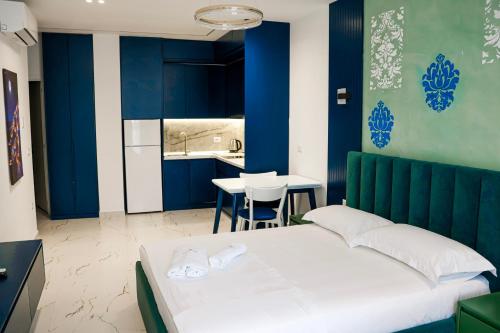 a bedroom with blue walls and a bed and a table at EKAM Sun Apartments in Golem