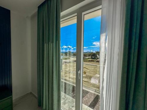 a room with a window with green curtains at EKAM Sun Apartments in Golem