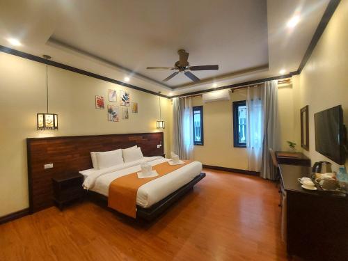 a large bedroom with a bed and a ceiling fan at Luang Prabang Meunna Hotel in Luang Prabang
