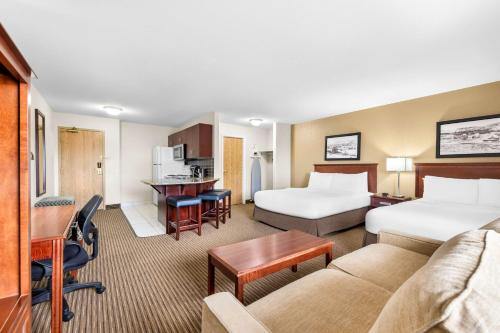 een hotelkamer met 2 bedden en een bank bij SureStay Plus Hotel by Best Western Drumheller in Drumheller