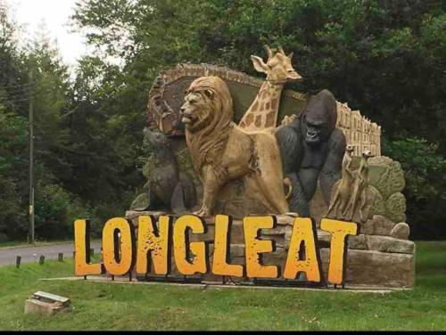 a statue of a lion and giraffes and a sign at brand new cozy cabin with parking in Trowbridge