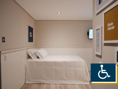 a small room with a bed with a sign on the wall at Apê Paulista Bela Cintra in Sao Paulo