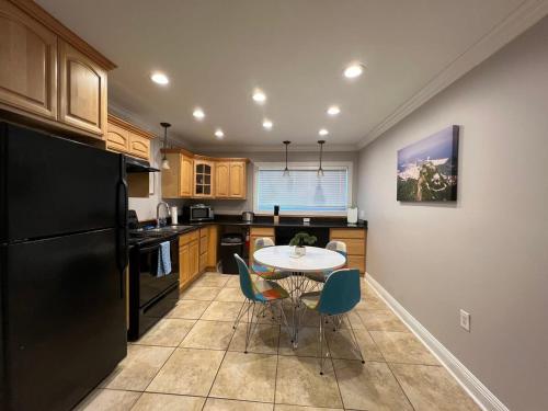 a kitchen with a black refrigerator and a table and chairs at Two bedroom apt with desk washer dryer & pool in Baton Rouge