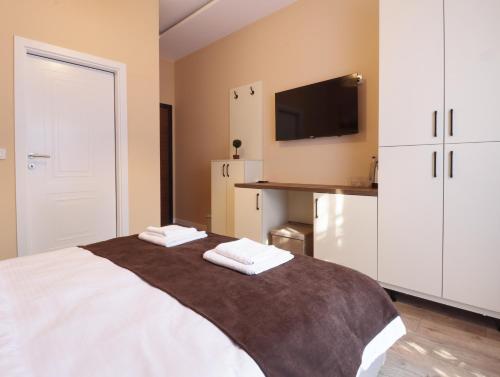 a bedroom with a bed with two towels on it at Midtown Prishtina Stays in Pristina
