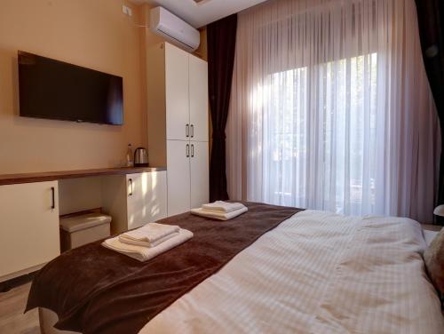 a bedroom with a bed with two towels on it at Midtown Prishtina Stays in Pristina