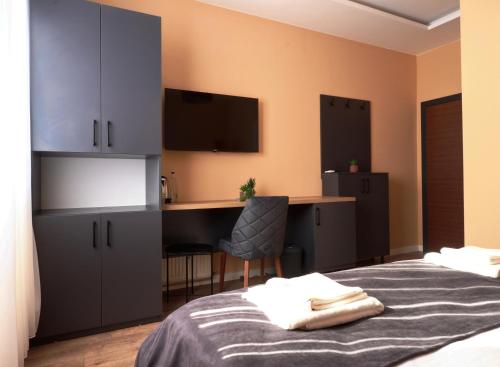 a bedroom with a bed and a desk and a computer at Midtown Prishtina Stays in Pristina