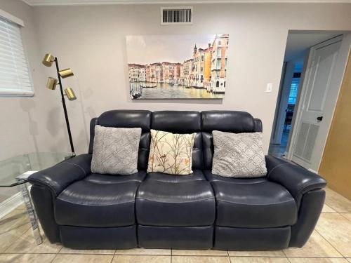 a black leather couch in a living room with pillows at Two bedroom apt with desk washer dryer & pool in Baton Rouge