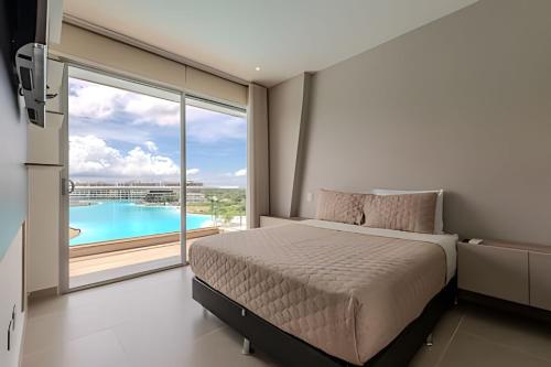ein Schlafzimmer mit einem Bett und Blick auf einen Pool in der Unterkunft Lujoso A Estrenar/Oasis Laguna Cristalina 2BR in Los Arrayanes