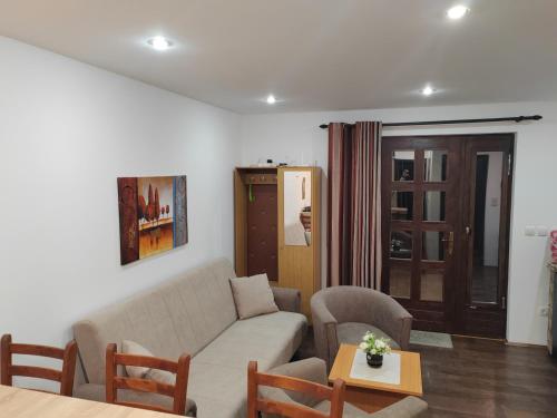 a living room with a couch and a table at Apartman Popadić-Goč in Biserske Kuće