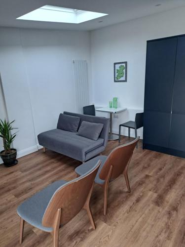 a living room with a couch and two chairs at Cavehill Cottage in Belfast