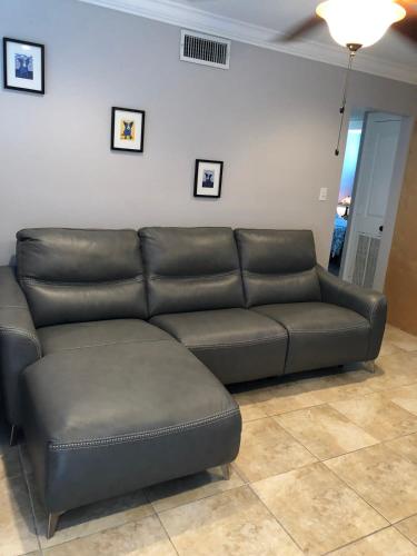 a brown leather couch in a living room at 2 br Steps from Tiger Stadium in Baton Rouge