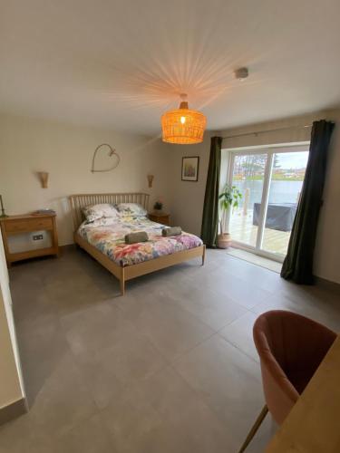 a bedroom with a bed and a large window at Luxurious and Peaceful Lakeside House, Clitheroe in Clitheroe
