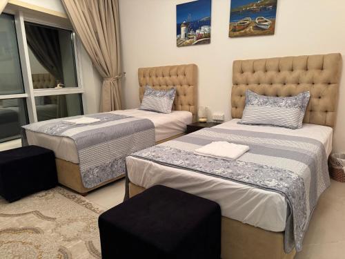 a bedroom with two beds and a window at The Family Spot in Sharjah