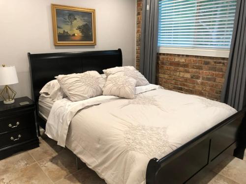 a bed with white sheets and pillows in a bedroom at 2 bedroom apartment next to LSU campus in Baton Rouge
