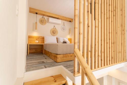 een kleine kamer met een bed en een houten trap bij Ionas Apartments 4 in Nea Skioni