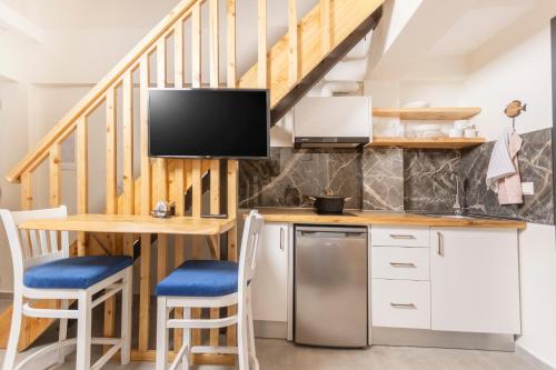 een keuken met een tafel en een tv aan de muur bij Ionas Apartments 4 in Nea Skioni