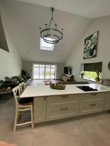 a kitchen with a island with a sink and a chandelier at Luxurious and Peaceful Lakeside House, Clitheroe in Clitheroe