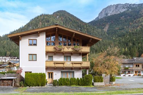 a house with a balcony in front of a mountain at Ferienwohnung Weiss in Waidring