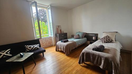a living room with a bed and a couch at Chambres et Gîtes Les Deux Chênes près de Bergerac in Le Fleix
