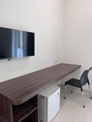 a wooden desk with a television on a wall at Morjim Sunset Guesthouse - 300 meter to Morjim Beach in Morjim