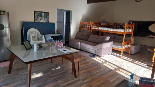 a living room with a couch and a table and a bed at Rancho Clara Luz in Guapimirim