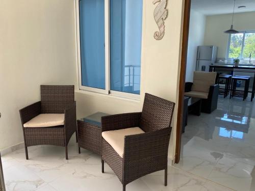 a living room with two chairs and a table at Sunrise ApartaHotel in El Manguito