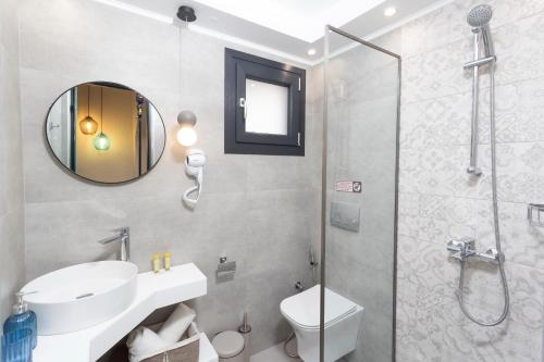een badkamer met een toilet, een wastafel en een douche bij Ionas Apartments 5 in Nea Skioni