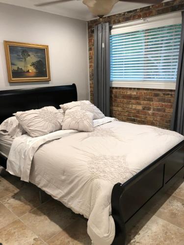 a bed with white sheets and pillows in a bedroom at 2 bedroom apartment next to LSU campus in Baton Rouge