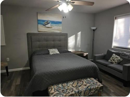 a bedroom with a bed and a couch and a ceiling fan at Vdara Pocono Home in Tobyhanna
