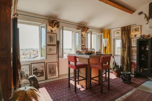a room with a table and two chairs and windows at Le Nid Exotique - vue sur les toits du centre-ville in Montpellier