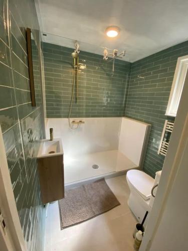 a bathroom with a tub and a toilet and a sink at Prachtig huisje met grote tuin op de Veluwe in Wenum